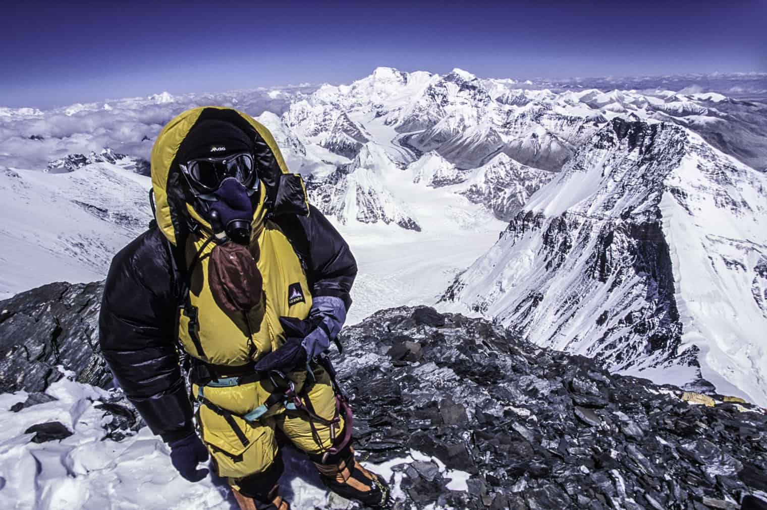 Alpiniste en haute altitude avec vue sur l'Everest enneigé.