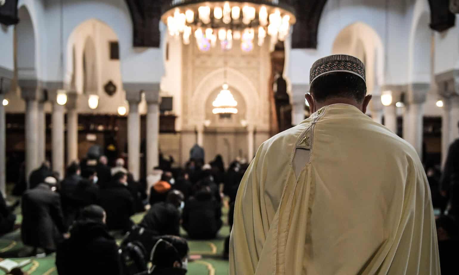 Imam en prière dans une mosquée lors d'une cérémonie religieuse.