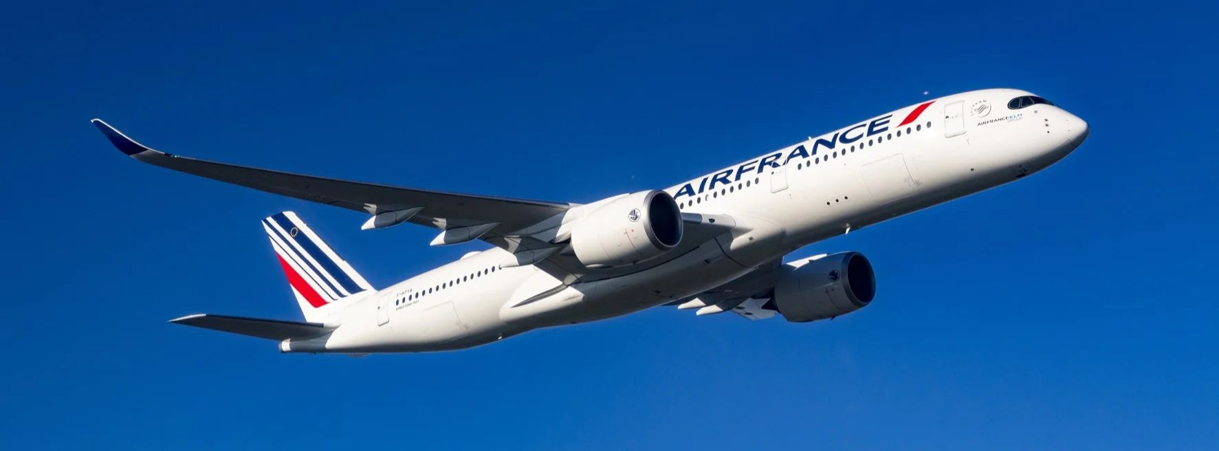 Avion Air France en vol dans un ciel bleu clair.
