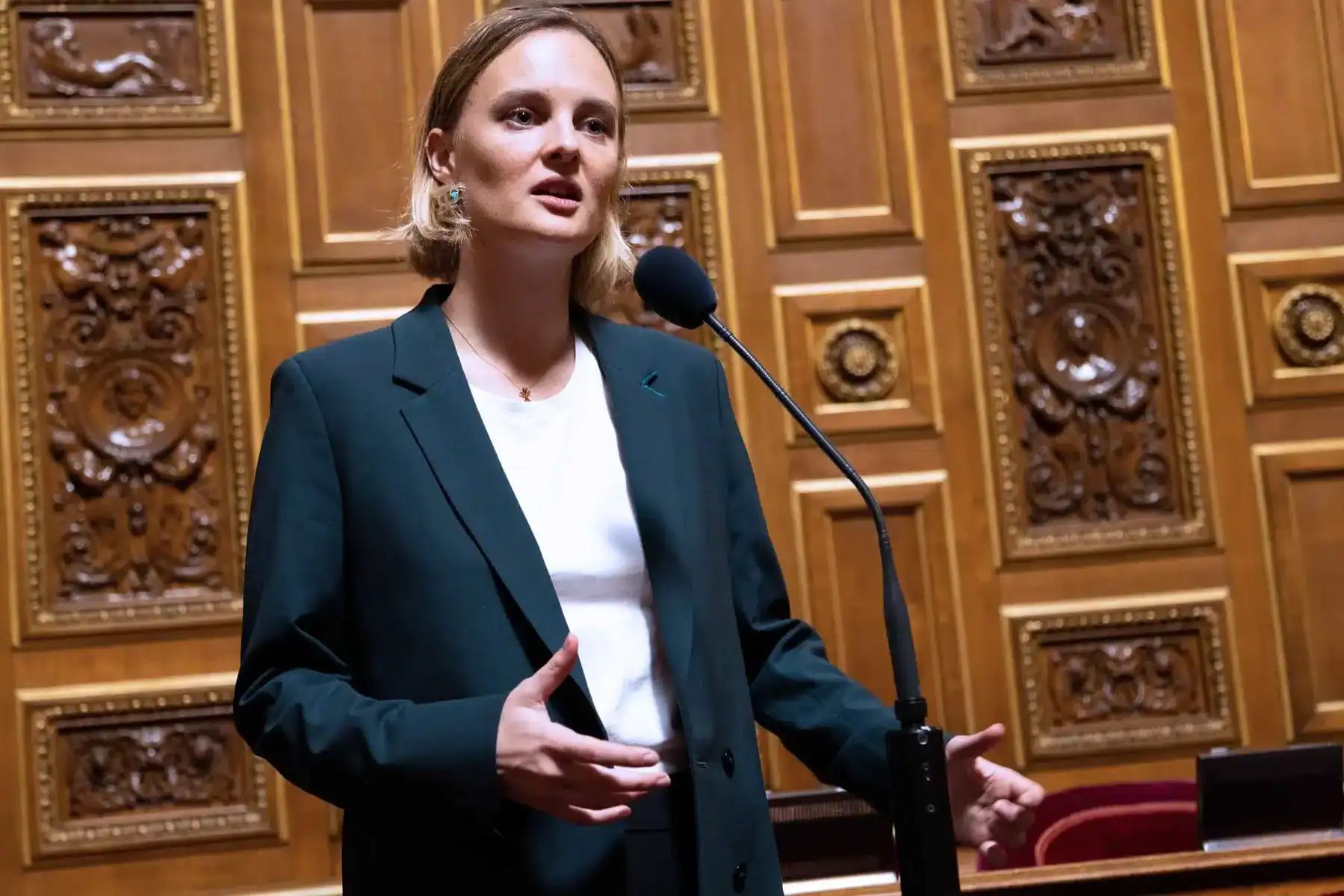 Sénatrice parlant à la tribune dans un cadre officiel.