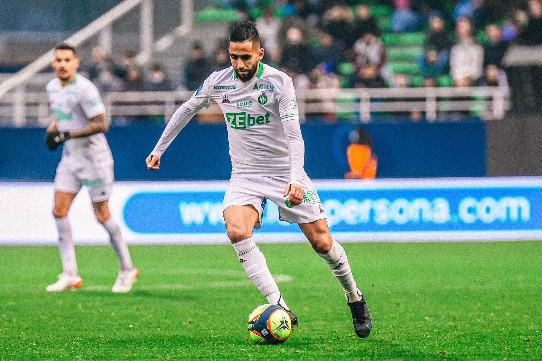 Ryad Boudebouz joue au football pour la JSK sur le terrain.