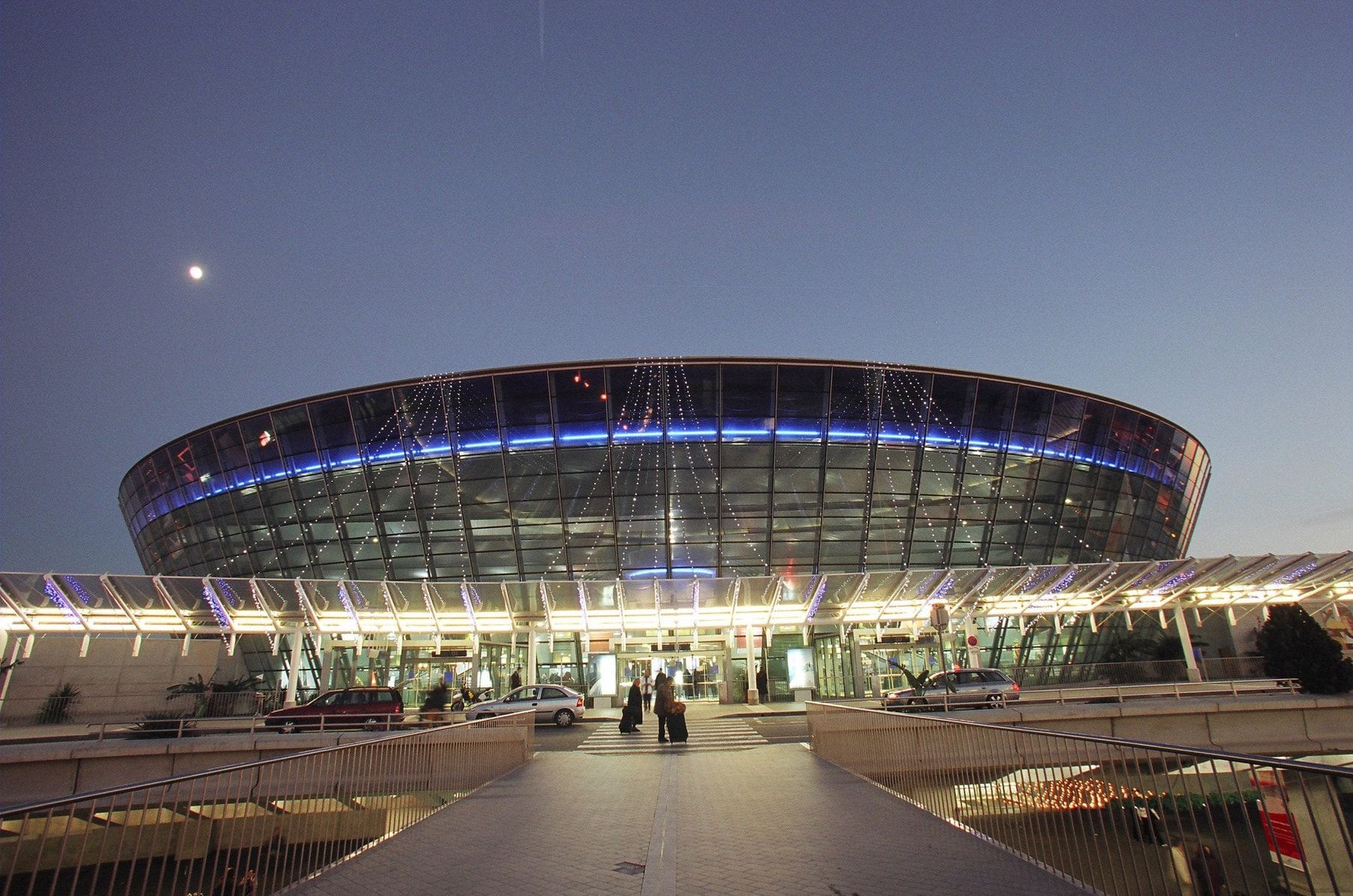 Vue de l'aéroport de Nice avec ciel nocturne et lune visible.