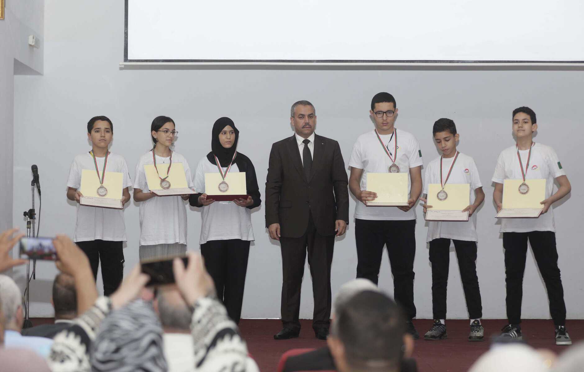 Jeunes talents algériens recevant des médailles lors d'une cérémonie.