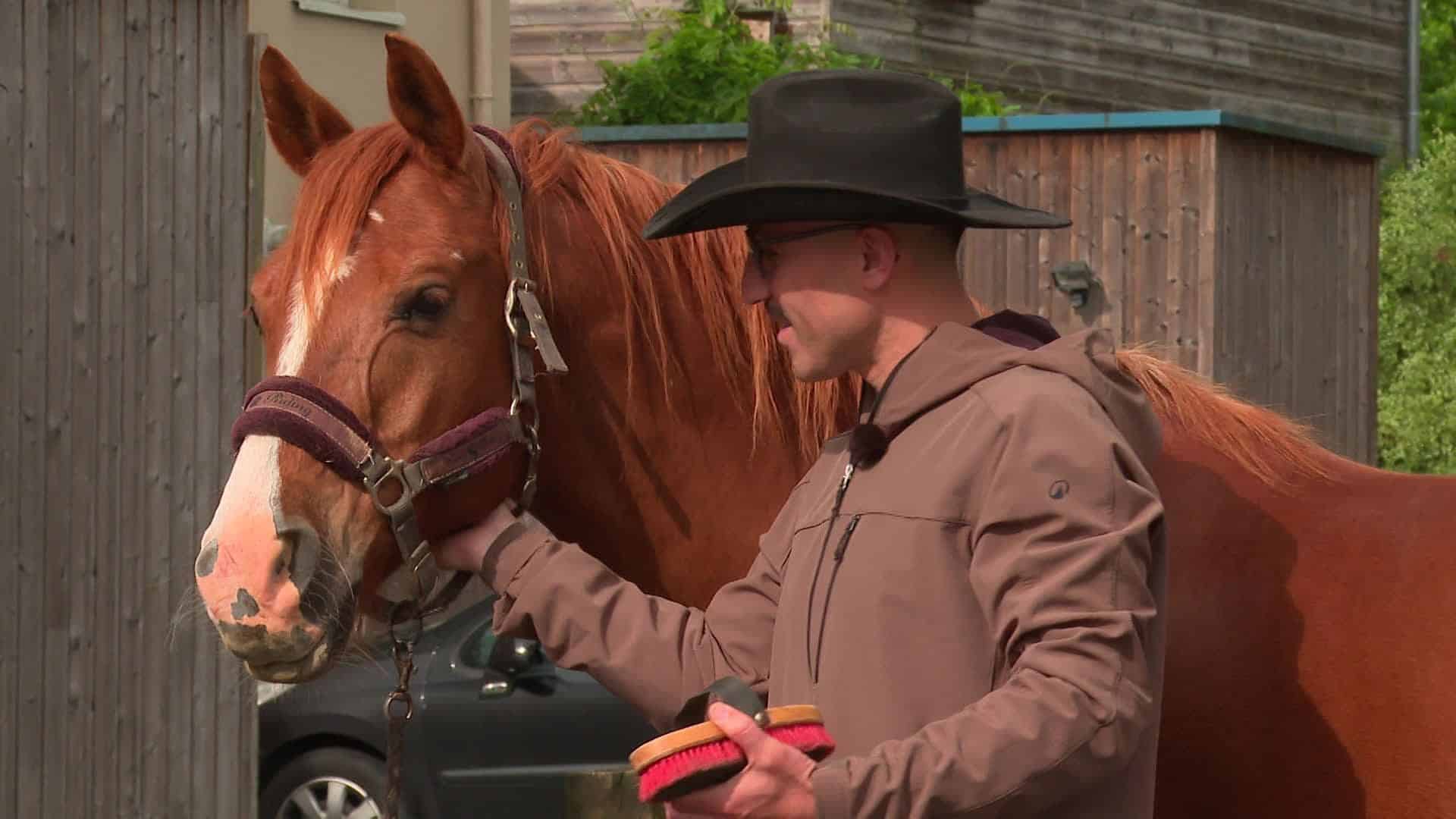 Mohamed Bourhis caressant un cheval en Algérie.
