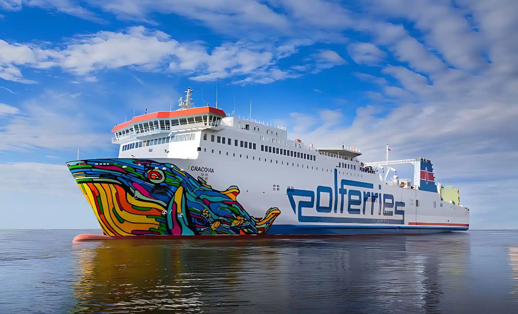 Ferry moderne avec design coloré sur l'eau sous un ciel bleu.