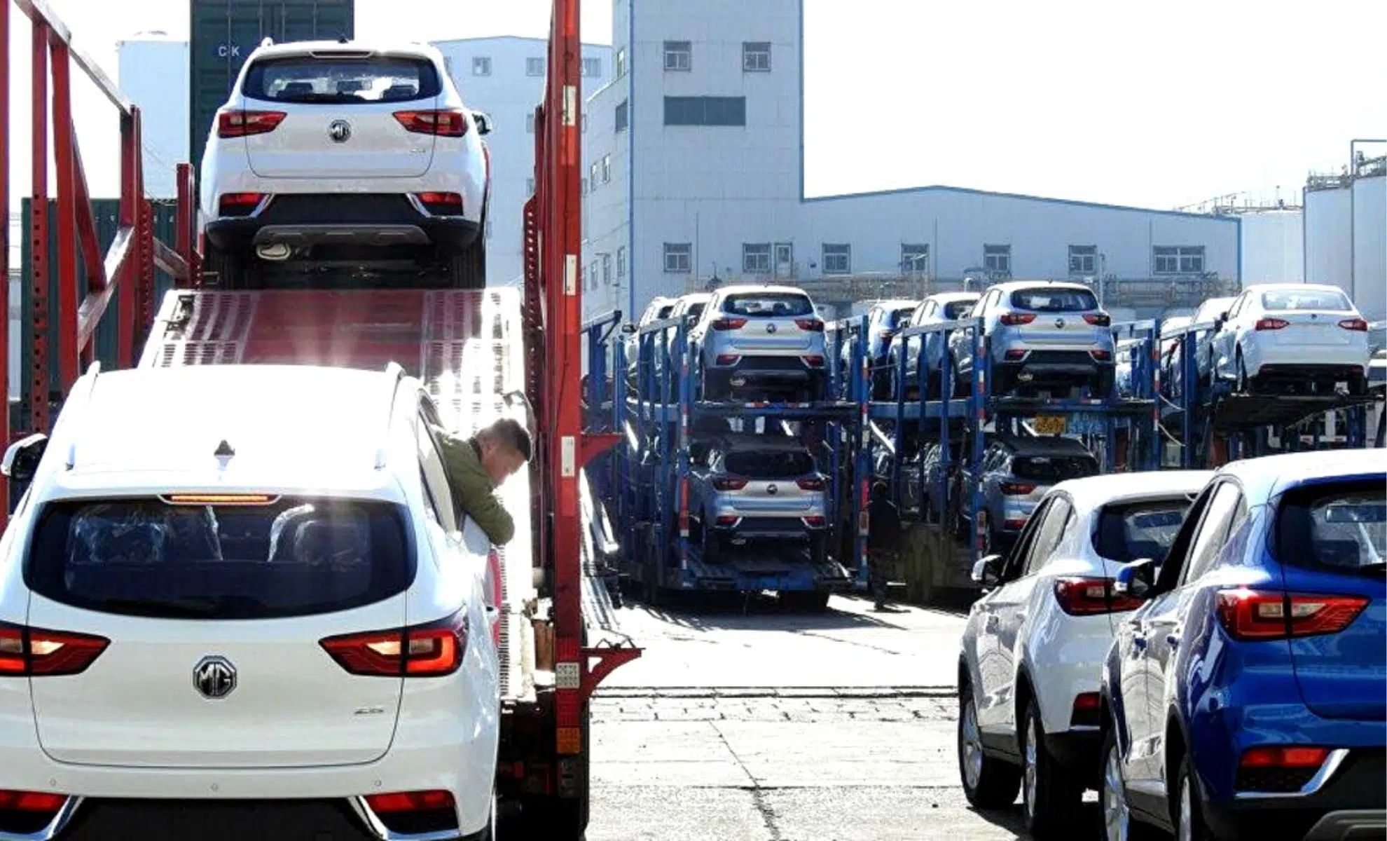 Transporteur chargeant une voiture neuve sur un camion de livraison.