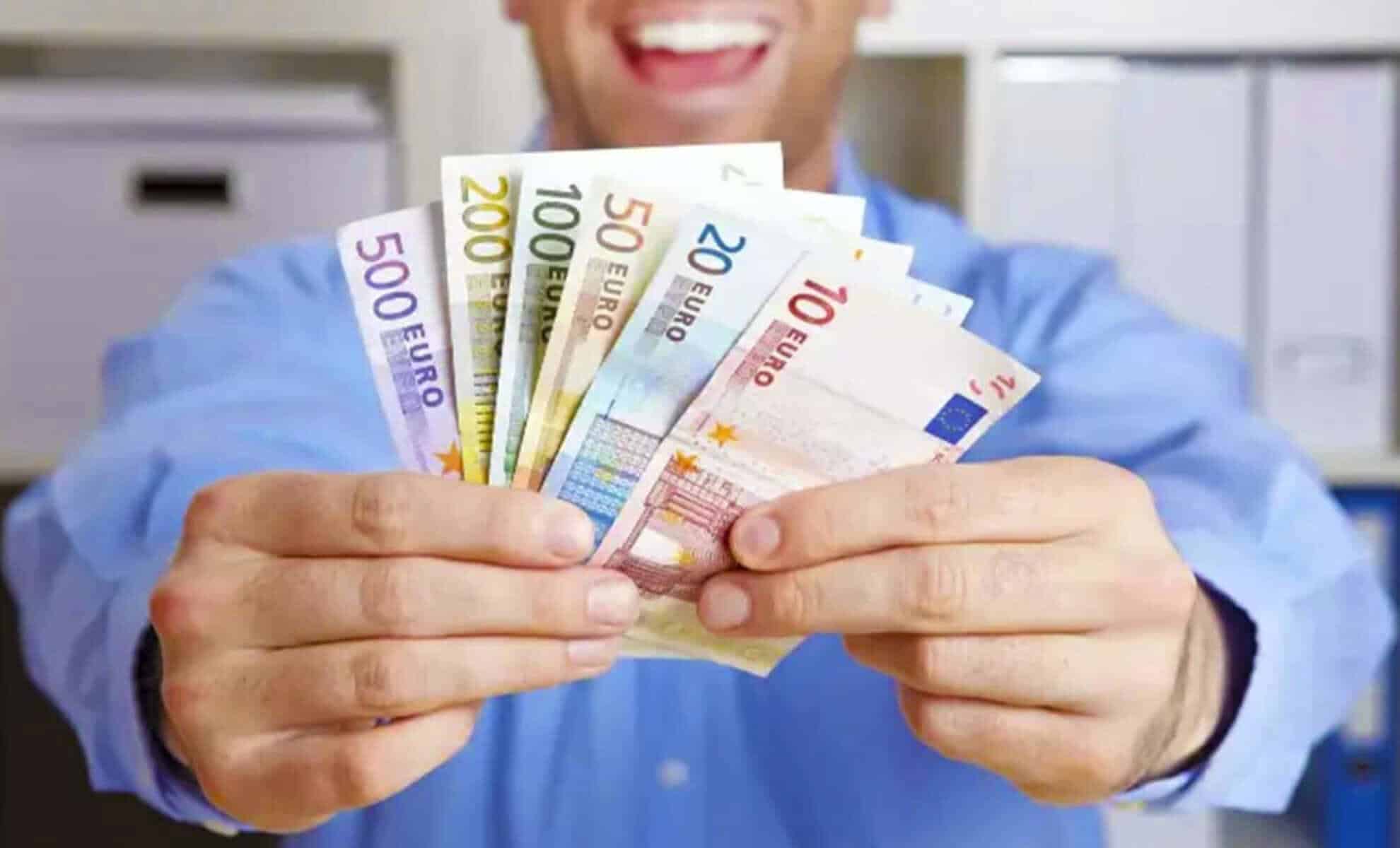 Personne tenant des billets de banque en euros.