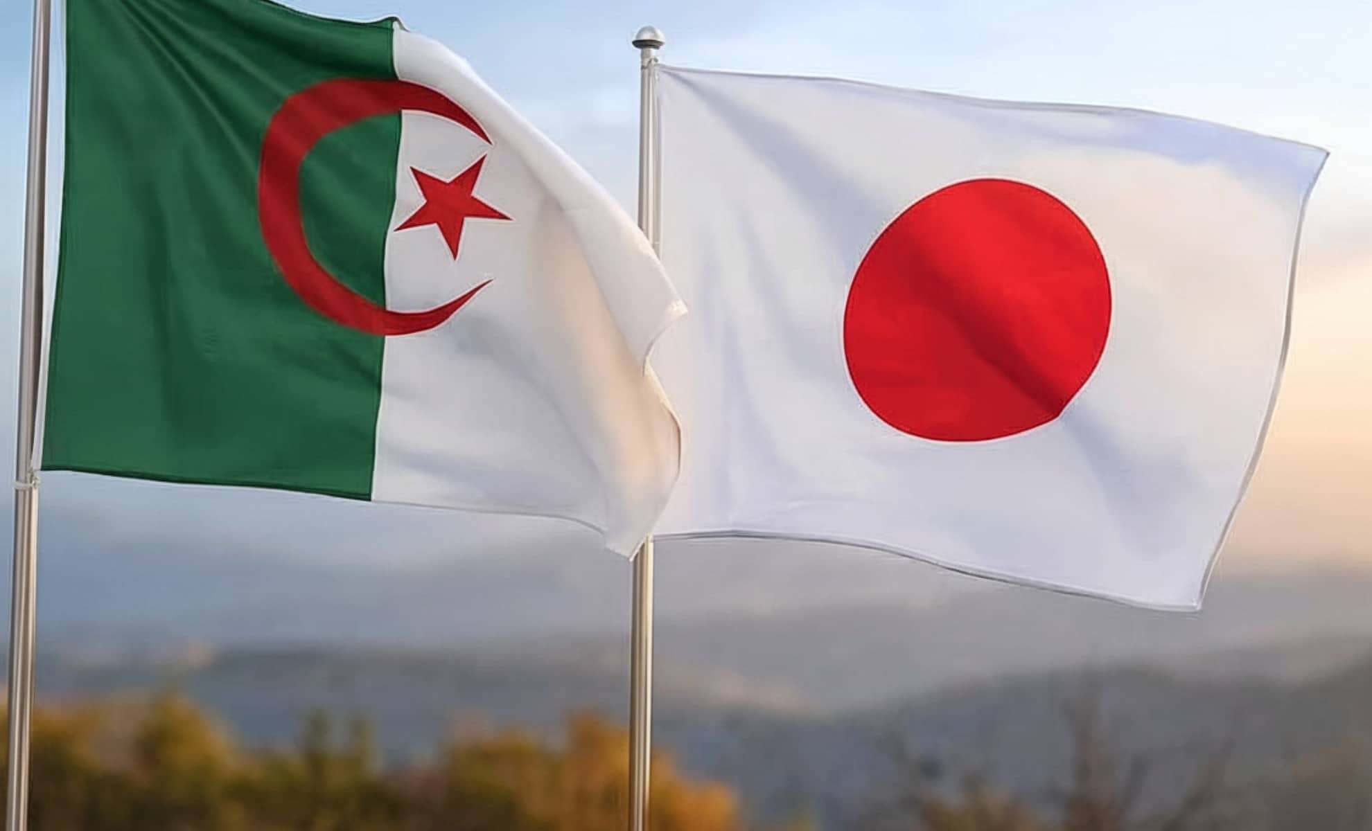 Drapeaux de l'Algérie et du Japon flottant dans le vent.