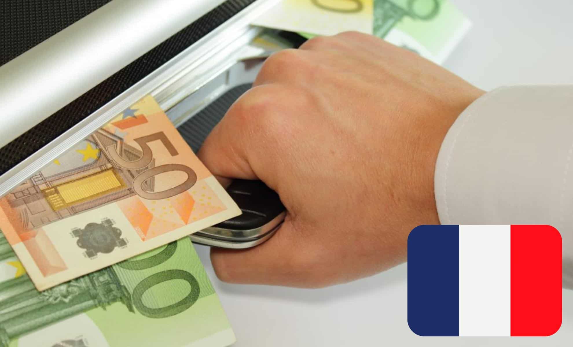 Main insérant de l'argent en euros dans un scanner de billets.