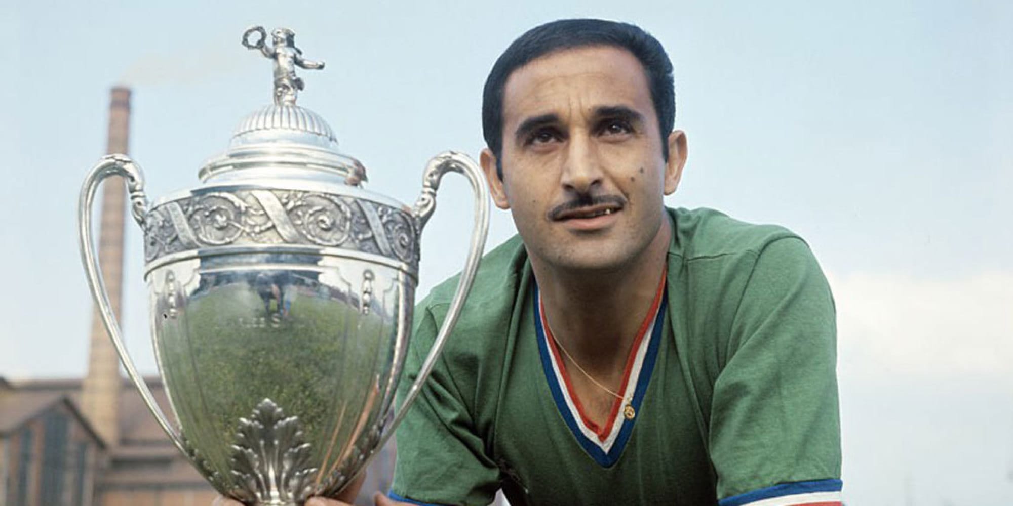 Rachid Mekhloufi, légende du football algérien, avec un trophée.