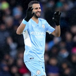 Mahrez souriant en tenue de football Manchester City.