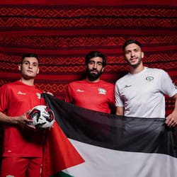 Trois joueurs palestiniens avec drapeau et ballon de football.
