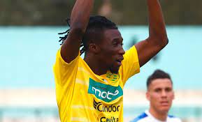 Joueur de football en maillot jaune célébrant sur le terrain.