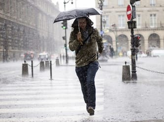 Personne marchant sous un parapluie dans la pluie à Paris.