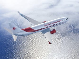 Avion d'Air Algérie survolant l'océan avec ciel nuageux.