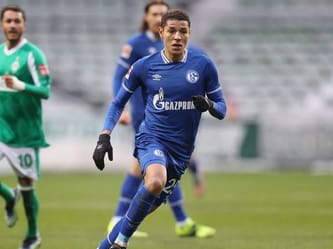 Joueur de Schalke 04 en pleine course sur le terrain de football.