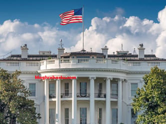 La Maison Blanche avec drapeau américain flottant dans le ciel.