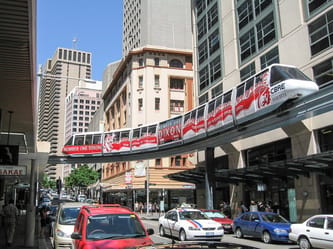 Monorail moderne traversant le centre-ville d'Alger avec des gratte-ciel.
