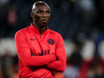 Nouveau coach du PSG en tenue rouge lors d'un match.