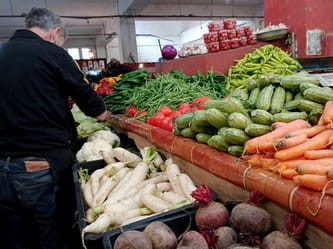 Vendeur de fruits et légumes dans un marché algérien.