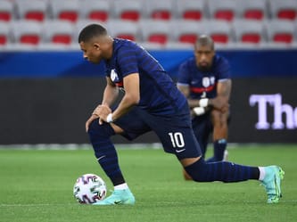 Kylian Mbappé en action sur le terrain de football.