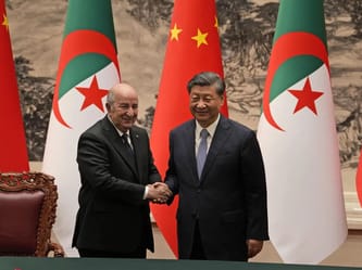 Le président algérien et le président chinois se serrent la main.
