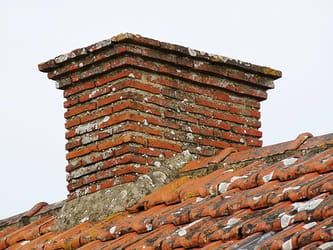 Cheminée en briques sur le toit d'une maison ancienne.