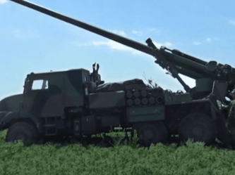 Véhicule d'artillerie avec canon long en position de tir.