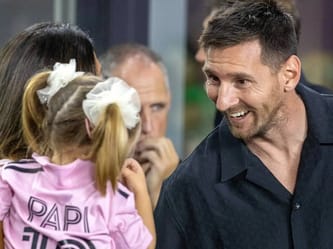 Lionel Messi souriant avec des jeunes fans lors d'un événement.