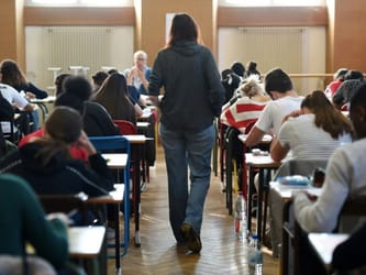 Étudiants en examen dans une salle de classe en France.
