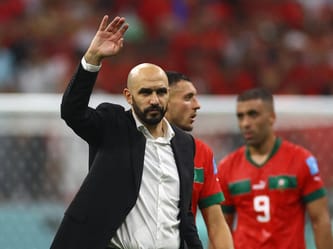 Walid Regragui saluant le public lors d'un match de football.