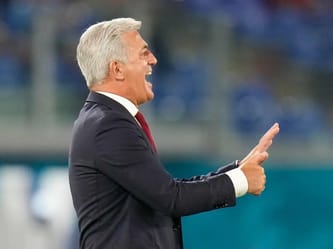 Entraîneur Petkovic souriant et pointant lors d'une rencontre sportive.