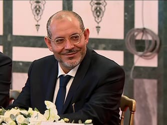 Imam en costume lors d'une réunion officielle en Algérie.