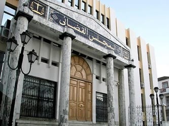 Bâtiment du Conseil de la nation avec colonnes en marbre et inscription en arabe.