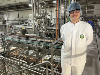 Femme en tenue de protection dans une usine industrielle moderne.