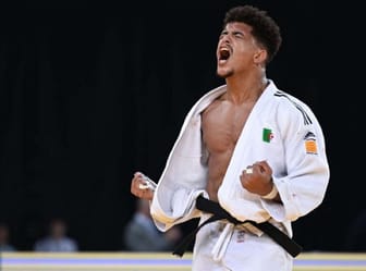Judoka algérien Dris Messaoud célèbre sa victoire en kimono blanc.
