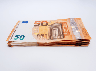 Billets de 50 euros empilés sur fond blanc.