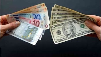 Main tenant des billets de dollars et d'euros pour un échange.