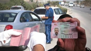Agent de police contrôlant une carte d'identité sur la route.