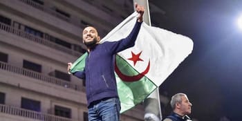 Homme algérien brandissant le drapeau national lors d'un événement.