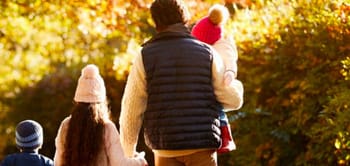 Famille avec deux enfants profitant d'une promenade automnale.