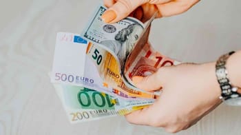 Main tenant des billets de banque en euros, monnaie européenne.