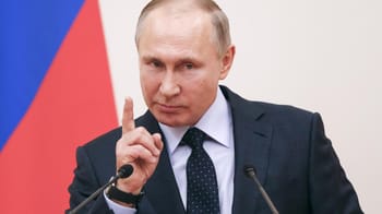 Vladimir Poutine faisant un geste lors d'une conférence officielle.