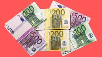 Billets de banque en euros de différentes denominations sur fond rouge.
