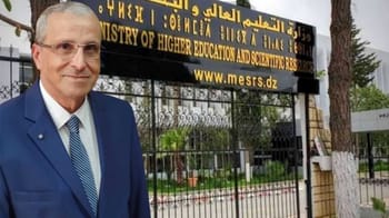 Homme en costume devant un bâtiment universitaire en Algérie.