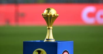 Trophée de football en or sur un podium bleu lors d'une compétition.