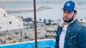 Jeune homme portant casquette New York et veste en jean à Tanger.