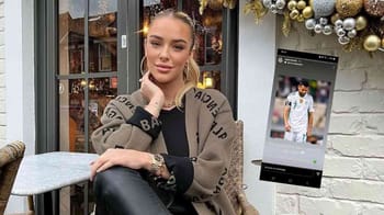 Jeune femme assise dans un café avec décor festif et écran numérique à Maghrebactu.