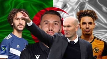 Trois joueurs de football algériens et un arbitre devant le drapeau algérien.