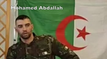 Mohamed Abdallah en uniforme militaire devant un drapeau algérien.